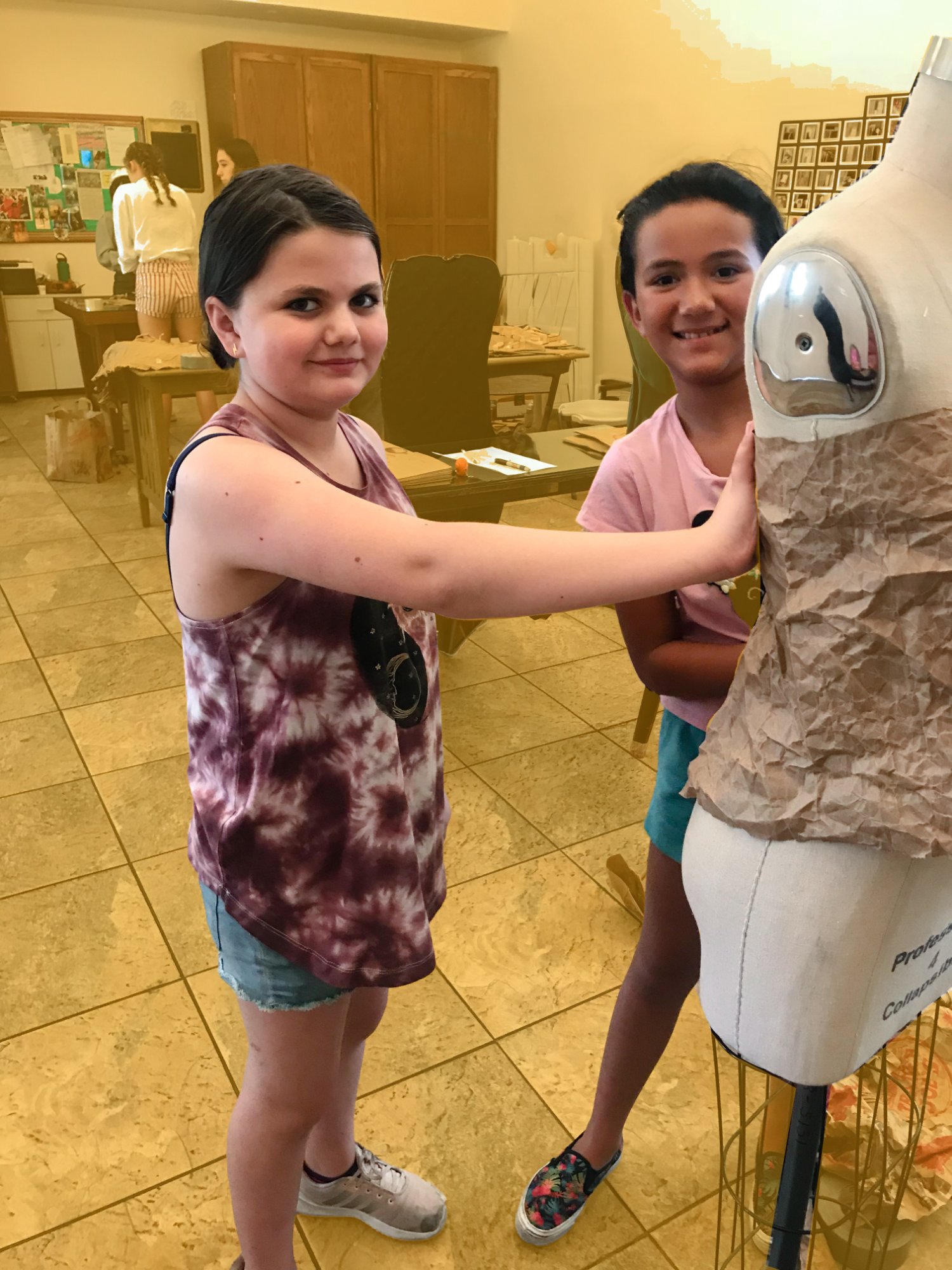 Instructor guiding a student at a sewing machine